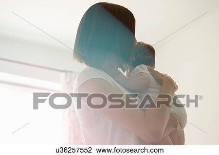 Mother carrying baby in bedroom View Large Photo Image Stock Image - Mother carrying baby in bedroom. Fotosearch