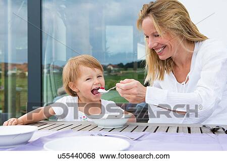Mother feeding toddler daughter a bowl of raspberries View Large Photo Image Stock Photo - Mother feeding toddler daughter a bowl of raspberries. Fotosearch