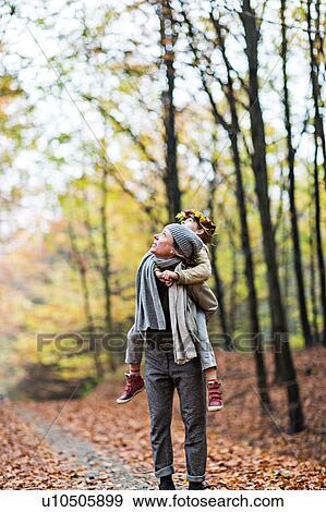 Mother giving daughter piggyback ride in autumn forest View Large Photo Image Stock Photo - Mother giving daughter piggyback ride in autumn forest. Fotosearch