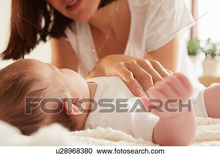 Mother playing with baby in bed View Large Photo Image Stock Image - Mother playing with baby in bed. Fotosearch