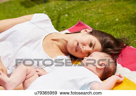 Mother playing with baby on grass View Large Photo Image Stock Photo - Mother playing with baby on grass. Fotosearch