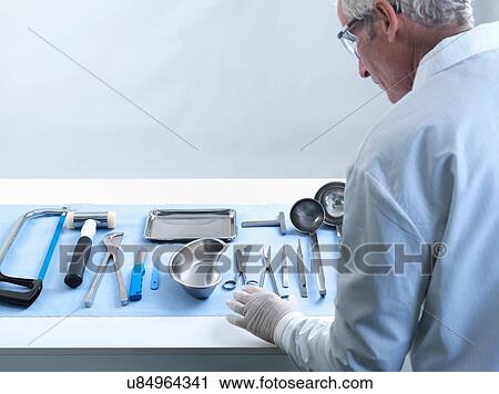 Stock Image - Pathologist preparing for autopsy. Fotosearch
