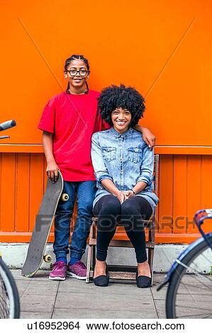 Picture - Portrait of boy and mother in front of orange wall. Fotosearch