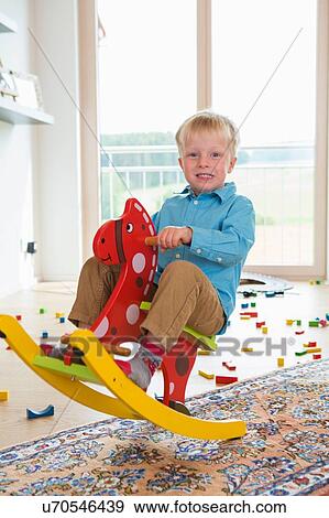 Portrait of boy playing on rocking horse View Large Photo Image Stock Photo - Portrait of boy playing on rocking horse. Fotosearch