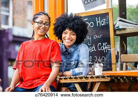 Portrait of boy sitting on mothers lap at sidewalk cafe View Large Photo Image Picture - Portrait of boy sitting on mothers lap at sidewalk cafe. Fotosearch