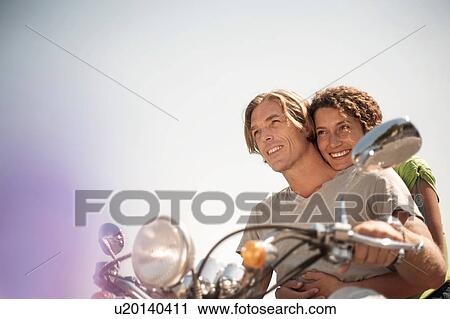 Stock Image - Portrait of couple on moped. Fotosearch