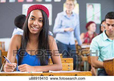 Portrait of female student, sitting at desk in classroom View Large Photo Image Stock Image - Portrait of female student, sitting at desk in classroom. Fotosearch