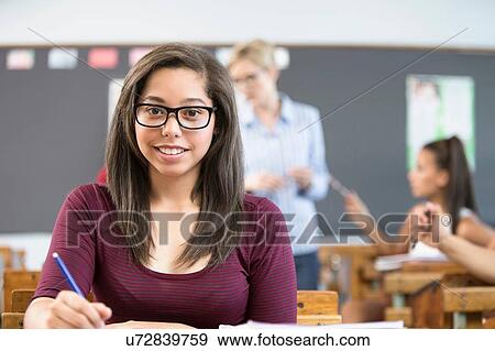 Portrait of female student, sitting at desk in classroom View Large Photo Image Stock Photo - Portrait of female student, sitting at desk in classroom. Fotosearch
