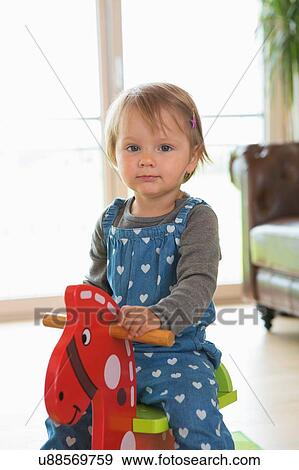 Portrait of female toddler playing on rocking horse View Large Photo Image Stock Photo - Portrait of female toddler playing on rocking horse. Fotosearch