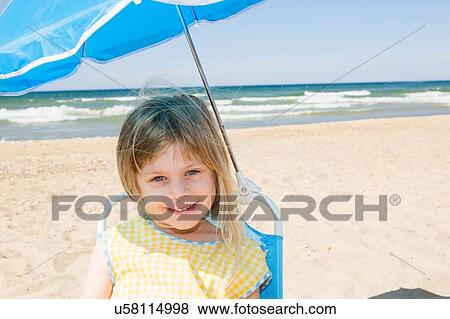 Portrait of girl in parasol shade on beach View Large Photo Image Stock Photo - Portrait of girl in parasol shade on beach. Fotosearch