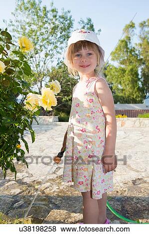 Portrait of girl wearing sunhat watering roses View Large Photo Image Stock Photo - Portrait of girl wearing sunhat watering roses. Fotosearch
