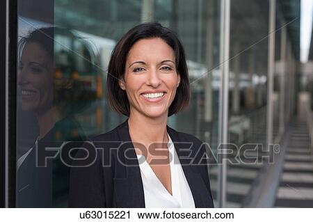 Stock Image - Portrait of happy mature businesswoman outside airport. Fotosearch