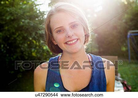 Picture - Portrait of happy teenage girl in garden. Fotosearch