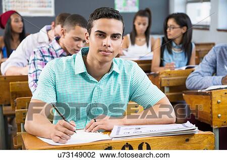 Portrait of male student, sitting at desk in classroom View Large Photo Image Stock Image - Portrait of male student, sitting at desk in classroom. Fotosearch