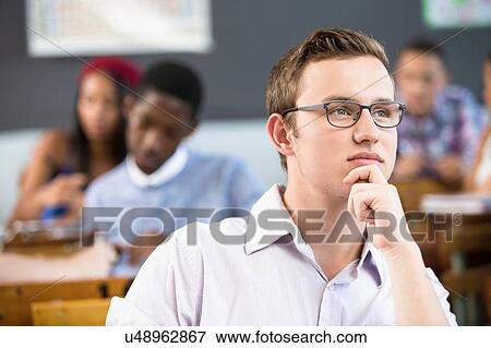 Portrait of male student, sitting at desk in classroom View Large Photo Image Stock Photo - Portrait of male student, sitting at desk in classroom. Fotosearch