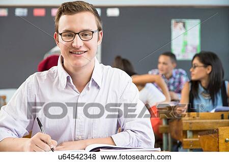 Portrait of male student, sitting at desk in classroom View Large Photo Image Stock Photo - Portrait of male student, sitting at desk in classroom. Fotosearch