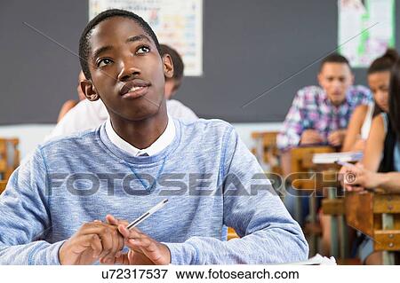 Portrait of male student, sitting at desk in classroom View Large Photo Image Stock Photo - Portrait of male student, sitting at desk in classroom. Fotosearch