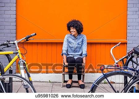 Portrait of mature woman sitting in front of orange wall View Large Photo Image Stock Photograph - Portrait of mature woman sitting in front of orange wall. Fotosearch