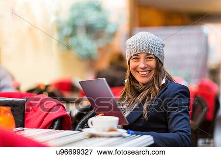 Stock Photo - Portrait of mature woman using digital tablet at sidewalk cafe. Fotosearch