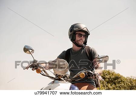 Portrait of mid adult man sitting on moped View Large Photo Image Stock Photo - Portrait of mid adult man sitting on moped. Fotosearch