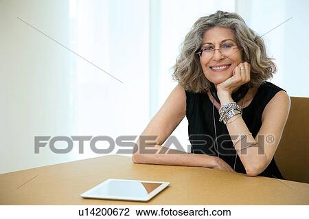 Portrait of senior female designer with digital tablet at boardroom table View Large Photo Image Stock Image - Portrait of senior female designer with digital tablet at boardroom table. Fotosearch