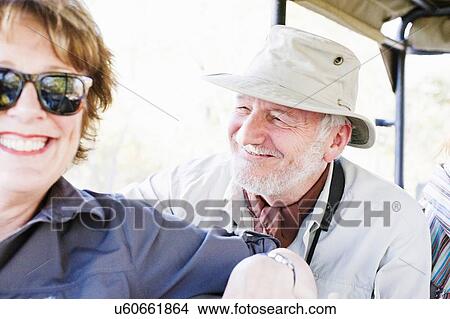 Picture - Portrait of senior man and wife on safari in four wheel drive, Kafue National Park, Zambia. Fotosearch