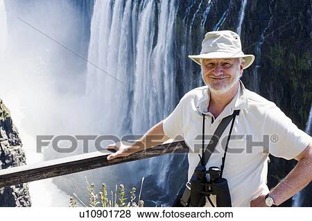 Stock Photo - Portrait of senior man at Victoria Falls, Zambia. Fotosearch