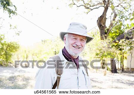 Stock Photography - Portrait of senior man on safari, Kafue National Park, Zambia. Fotosearch