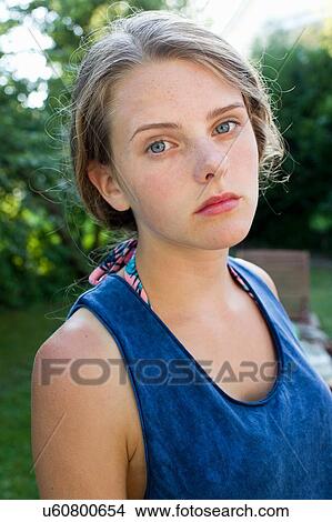 Picture - Portrait of sullen teenage girl in garden. Fotosearch