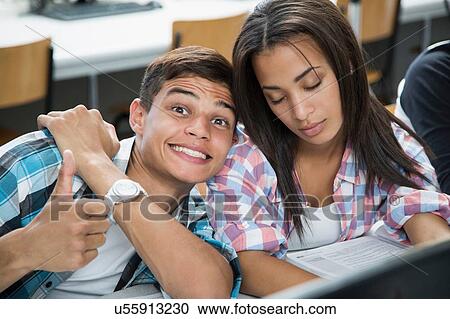 Portrait of teenage boy with cheesy grin and girl with eyes closed in class View Large Photo Image Stock Image - Portrait of teenage boy with cheesy grin and girl with eyes closed in class. Fotosearch