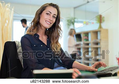 Portrait of young businesswoman at office desk View Large Photo Image Stock Photo - Portrait of young businesswoman at office desk. Fotosearch