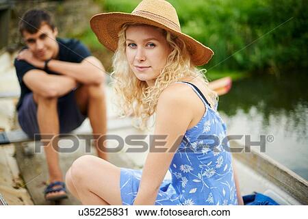 Stock Image - Portrait of young couple in rowing boat on river. Fotosearch
