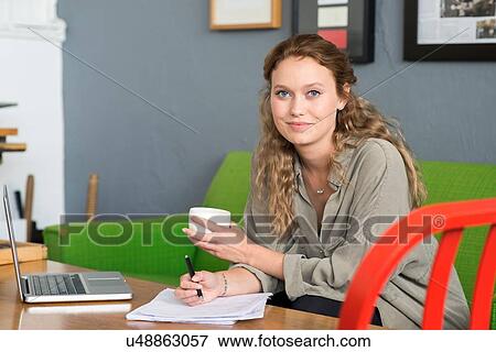 Stock Photo - Portrait of young female designer on office sofa. Fotosearch