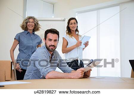 Portrait of young male businessman and two female colleagues in office View Large Photo Image Stock Photo - Portrait of young male businessman and two female colleagues in office. Fotosearch