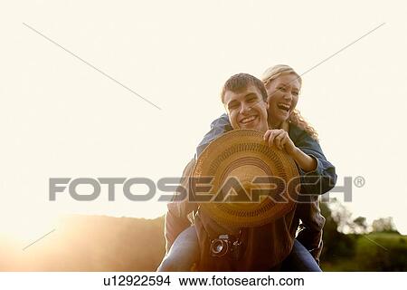 Portrait of young man giving girlfriend a piggyback View Large Photo Image Picture - Portrait of young man giving girlfriend a piggyback. Fotosearch