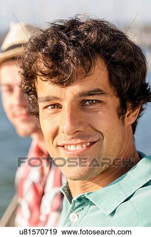 Portrait of young man looking at camera smiling View Large Photo Image Stock Photo - Portrait of young man looking at camera smiling. Fotosearch