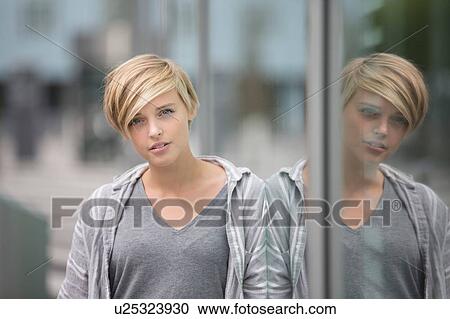 Portrait of young woman and her mirror image in city window View Large Photo Image Stock Image - Portrait of young woman and her mirror image in city window. Fotosearch