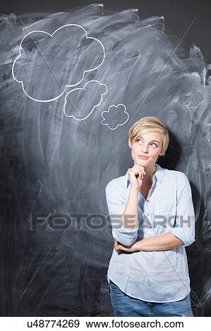 Portrait of young woman in front of thought bubbles on blackboard View Large Photo Image Stock Photo - Portrait of young woman in front of thought bubbles on blackboard. Fotosearch