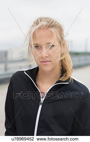 Stock Image - Portrait of young woman, wearing sports clothing, outdoors. Fotosearch