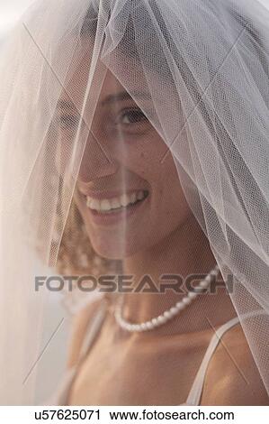 Stock Image - Portrait of young woman wearing wedding dress and veil. Fotosearch