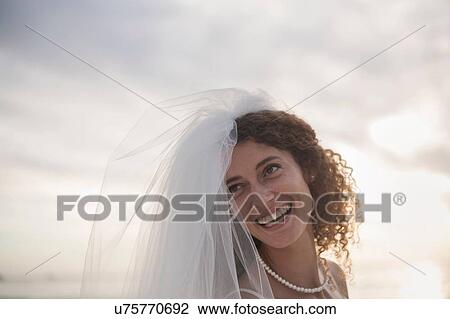 Portrait of young woman wearing wedding dress and veil, smiling View Large Photo Image Stock Image - Portrait of young woman wearing wedding dress and veil, smiling. Fotosearch