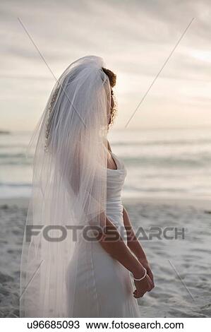 Stock Image - Portrait of young woman wearing wedding dress and veil. Fotosearch