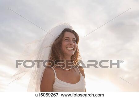 Portrait of young woman wearing wedding dress and veil, smiling View Large Photo Image Stock Photo - Portrait of young woman wearing wedding dress and veil, smiling. Fotosearch