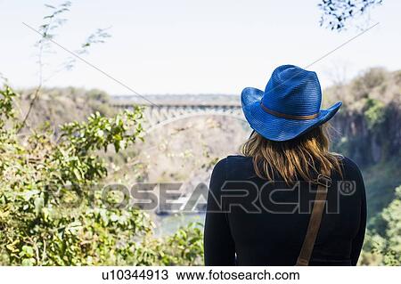 Rear view of young woman looking out at bridge, Victoria Falls, Zambia View Large Photo Image Stock Image - Rear view of young woman looking out at bridge, Victoria Falls, Zambia. Fotosearch