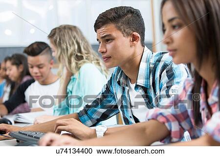 Row of teenage high school students concentrating in computer class View Large Photo Image Stock Image - Row of teenage high school students concentrating in computer class. Fotosearch