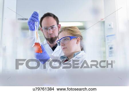 Picture - Scientists inspecting coloured samples in testing laboratory. Fotosearch