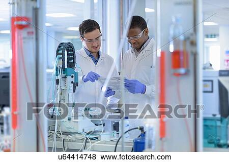 Stock Photo - Scientists inspecting coloured samples in testing laboratory. Fotosearch