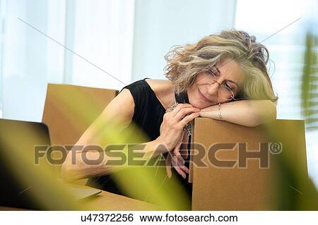 Stock Photograph - Senior businesswoman relaxing on office chair. Fotosearch