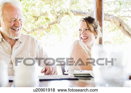 Stock Photo - Senior man and daughter reading menu at safari lodge, Kafue National Park, Zambia. Fotosearch