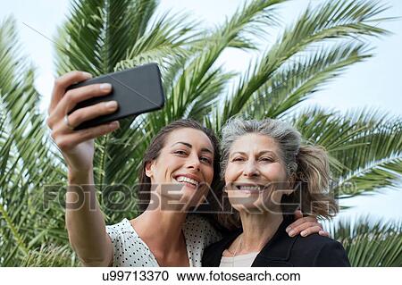 Senior woman and daughter taking smartphone selfie View Large Photo Image Stock Image - Senior woman and daughter taking smartphone selfie. Fotosearch